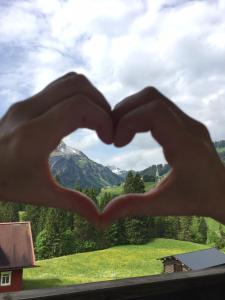 a pair of hands making a heartshape at Gästehaus Wildbach in Mittelberg