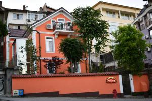 un bâtiment oranger avec des arbres devant lui dans l'établissement Vitality Guest House, à Veliko Tarnovo