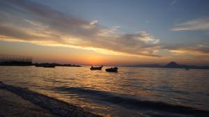 two boats in the water at sunset on the beach at Patras Cozy Lodge in Patra