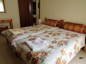 a bedroom with a large bed with a floral bedspread at Holiday Dream Thalia Apartment in Mastichari