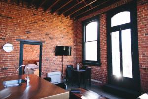 a brick walled room with a table and a television at The Terminus in Dunedin