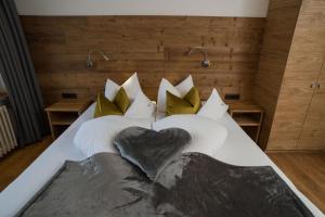 un letto con cuscini bianchi e un cuore sopra di Gästehaus Wildbach a Mittelberg