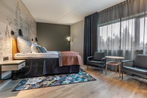 a hotel room with a bed and two chairs at Quality Airport Hotel Gardermoen in Gardermoen +77 photos
