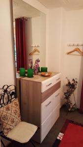 a bathroom with a vanity with a mirror and a chair at Sylvias Ranch in Gerstungen