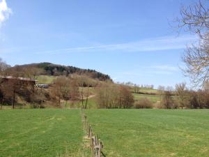 una valla en un campo con una colina en el fondo en Haus an der Diemel, en Diemelsee