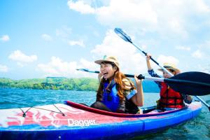two people in a kayak on the water at Guest House LAMP Lake Nojiri in Shinano