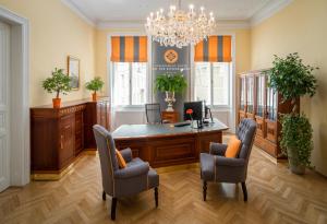 an office with a desk and chairs and a chandelier at Appartement-Hotel an der Riemergasse in Vienna