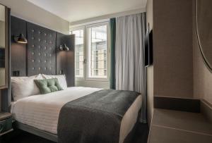 a bedroom with a large bed with a window at Point A Hotel Edinburgh Haymarket in Edinburgh