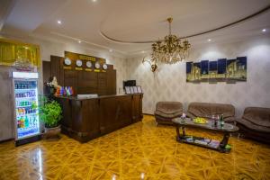 vestíbulo con sofá, mesa y nevera en Amina hotel en Samarcanda