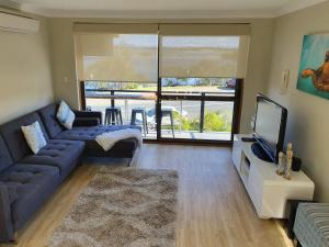 a living room with a couch and a tv at Wallis View 13 in Forster