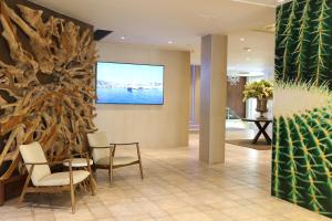 un vestíbulo con sillas y una gran pintura en la pared en Hotel Kaktus Playa - Adults Recommended, en Calella