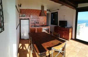 eine Küche mit einem Holztisch und einem Kühlschrank in der Unterkunft Il Moro in Geremèas