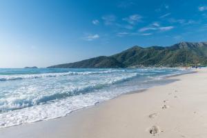 a beach with footprints in the sand and the ocean at Princess Golden Beach Hotel in Chrysi Ammoudia