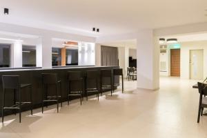 a lobby with a bar with black chairs at Princess Golden Beach Hotel in Chrysi Ammoudia +37 photos