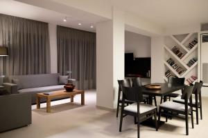 a living room with a couch and a table and chairs at Princess Golden Beach Hotel in Chrysi Ammoudia