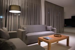 a living room with a couch and a coffee table at Princess Golden Beach Hotel in Chrysi Ammoudia