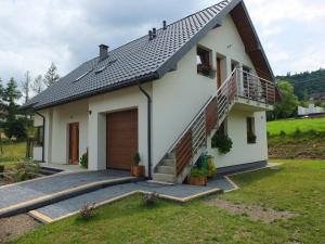 een wit huis met een veranda en een balkon bij Sloneczna Kwatera in Cisna