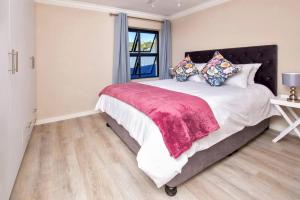a bedroom with a large bed and a window at Seacrest Cottage in Knysna