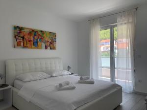 1 dormitorio con 1 cama blanca y 2 toallas en Apartments Danica, en Promajna
