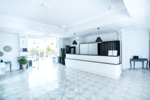 W pokoju znajduje się biała kuchnia z podłogą wyłożoną białymi kafelkami. w obiekcie Bianco Olympico Beach Resort-All Inclusive w mieście Vatopedi