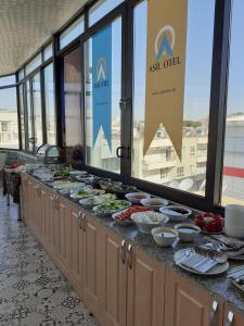 una línea de buffet con platos de comida. en ASİL OTEL, en Sanlıurfa