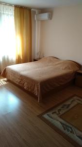 a bed in a bedroom with a window and a rug at Къща за гости Фантазия in Tryavna