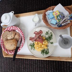 a tray with a plate of breakfast food on it at Pension Prislin in Litoměřice
