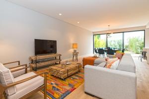 Una sala de estar con un sofá y un televisor de pantalla plana. en King's Cascais Apartment, en Cascais