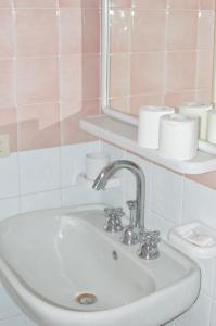 a bathroom with a sink and a mirror and a toilet at Hotel Polito in Ischia