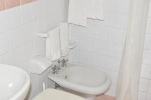 Baño blanco con lavabo y aseo en Hotel Polito, en Isquia