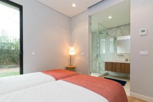 Un dormitorio con una cama y una ducha de cristal. en King's Cascais Apartment, en Cascais 39 fotos más