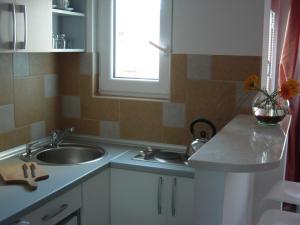 eine kleine Küche mit Spüle und Fenster in der Unterkunft Villa Tenžera in Herceg-Novi + 28 Fotos