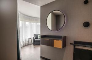 uma sala de estar com um espelho na parede em Point A Hotel Edinburgh Haymarket em Edinburgo