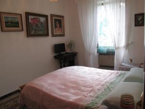 1 dormitorio con cama y ventana en Casa Marcella, en La Spezia