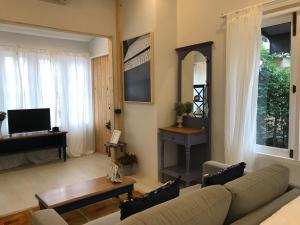 a living room with a couch and a table at P.O.E Posh Homestay in Cha Am