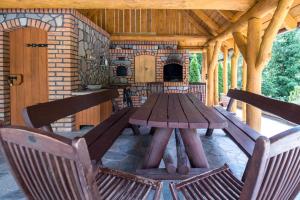 a wooden table and chairs on a patio with a fireplace at Agro-Wda in Czarna Woda