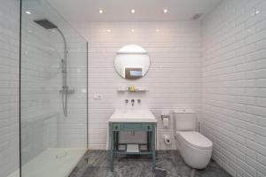 a bathroom with a sink and a toilet and a mirror at Apartamentos Habitavit en Cáceres in Cáceres +55 photos