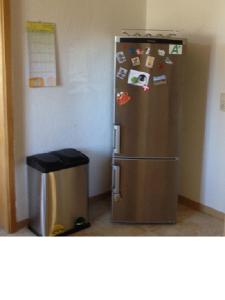 um frigorífico de aço inoxidável numa cozinha com uma lata de lixo em Ferienwohnung Ostseeblick em Insel Poel