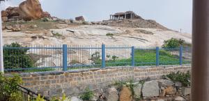 a blue fence in front of a rock hill at Padmaa Hampi Villa in Hampi