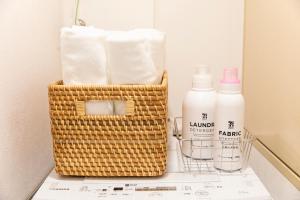 a basket of towels and bottles of toilet paper at RIVER SUITES HIROSHIMA in Hiroshima