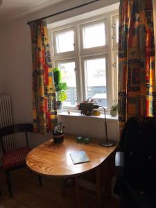 una mesa de madera en una habitación con ventana en Jette’s værelsesudlejning, en Rudkøbing