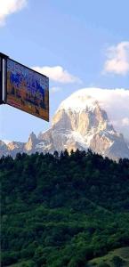 a snow covered mountain with a sign in front of it at Guest House Guli in Mestia