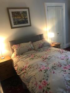 a bedroom with a bed with flowers on it at Garden Double Room with own door access and bathroom in Rostrevor