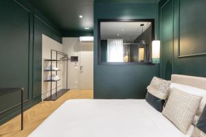 a bedroom with green walls and a bed with a mirror at The Mendeli Suite in Rome