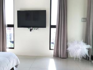a bedroom with a flat screen tv on the wall at The Corner 10 in Rende