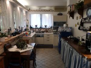 cocina con mesa, fogones y nevera en La Casa Sull'Albero, en Mestre