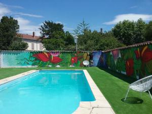 a swimming pool in a yard with a mural at MOODz HOTEL VIENNE in Pont-Évêque