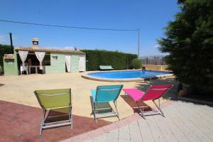 3 chaises assises en face d'une piscine dans l'établissement Chalet en Librilla, à Murcie