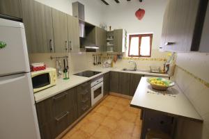 a kitchen with wooden cabinets and a bowl of fruit on a counter at Chalet en Librilla in Murcia