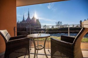 a balcony with a table and chairs and a view of a castle at Penzion a Restaurant Barbora in Kutná Hora